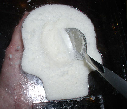 Scooping out excess sugar and egg white from the calavera